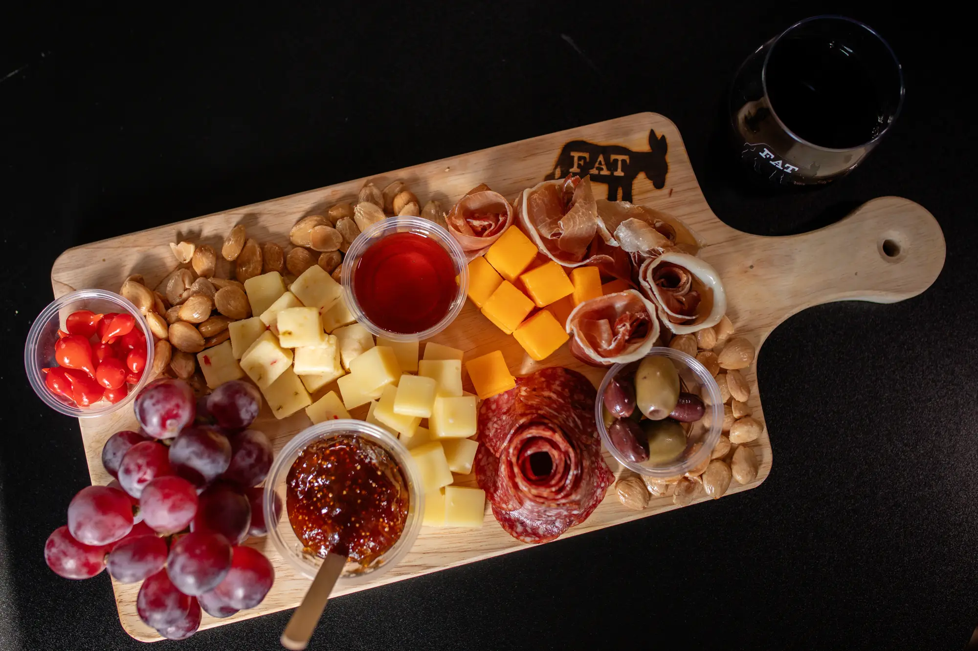 Charcuterie board and a glass of Fat Ass wine